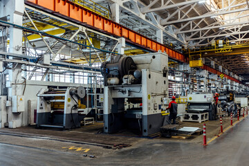 Workers and industrial machinery at metalworking factory production line