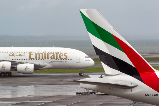Auckland, New Zealand - April 26, 2011: Emirates Airlines Airbus A380 aircraft taxis past the tail of Emirates airlines Boeing 777 aircraft.