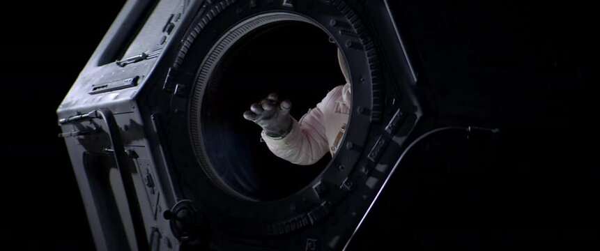 Portrait of Caucasian female astronaut flying towards spaceship cupola window. Space exploration, Mars mission. Shot with 2x anamorphic lens