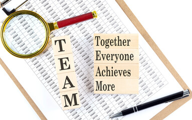 TEAM together everyone achieves more text on wooden block on chart background