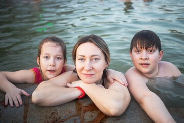 Fototapeta premium children indulge and play in the water of the hot spring during holidays and holidays undergoing treatments in the thermal pool