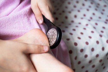 cleaning of the foot and heel with an abrasive stone with pimples, a beauty procedure after a shower bath for every day