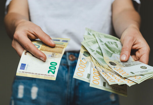 Money banknotes in hands, paper currency, exchanging money. Serbian dinars and euro paper currency.