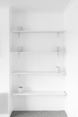 minimalist white wall with shelves in a niche and white plant pots, modern interior design and simple home improvements