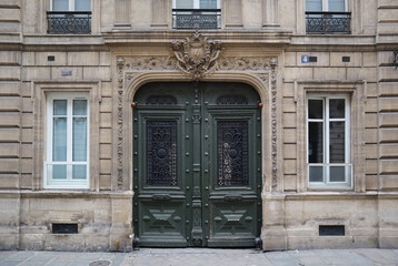 Fototapeta na wymiar Beautiful dark green door in an old 19th century building in Paris