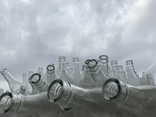 Transparent necks of retro bottles against a gloomy sky