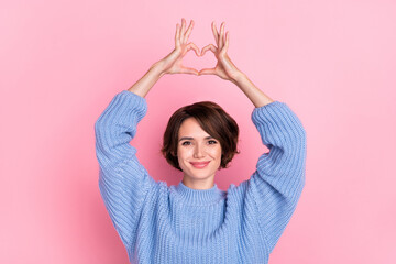 Portrait of gorgeous positive lady arms make heart symbol above head isolated on pink color background