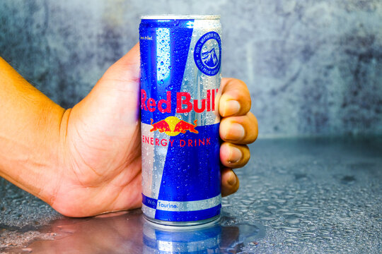 A picture of hand holding cold Red Bull Energy Drink. Red Bull has the highest market share of any energy drink in the world.