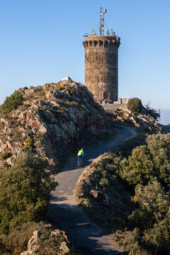A lone cyclist nears the end of the 650 metre ascent to the medieval Tour de Madeloc in the Pyrenees-Orientales region of southern France