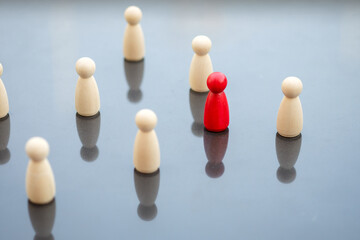 Red wooden figure as unique stands in a crowd of wooden figures. Human Resource Management and Recruitment and Hiring concept.