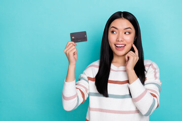 Photo of cute adorable lady happy to have credit card using cashback option isolated on turquoise...
