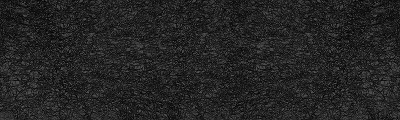 Crumpled black foil surface top view wide panoramic texture. Dark gray abstract large long background