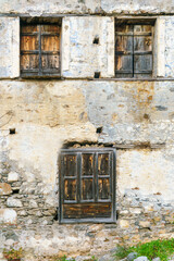 Old wall of an ancient house. Wooden shutters on the windows