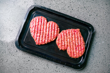 Meat cutlet in the shape of a heart. Vacuum pack of two cutlets. Dinner for lovers on February 14. Meat love. Valentine's Day.