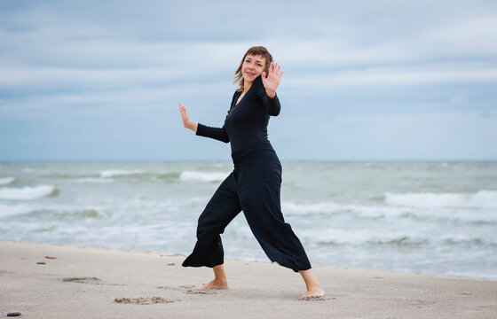 Cheerful woman dancing near the sea