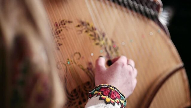 Rare stringed instrument. The girl in the embroidered shirt plays the traditional Ukrainian bandura instrument. Performance at the concert