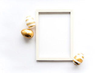 Gold white eggs on a white background with space for copy space for text in a frame. Minimal concept. View from above. Easter card, soft selective focus.