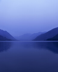 Lake Teletskoye, Altai Republic, Russia. Blue clear sky and Mirror of lake. Abstract panoramic landscape with natural gradient blue color, nature environment scene, monochrome background