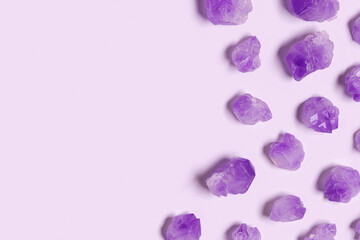 Purple amethyst crystals on very peri color background with copy space,  top view natural beautiful gemstone as geometric layout. Amethyst stone healing crystal, precious gem, flat lay