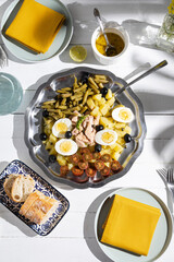 Potato salad with tuna, boiled egg, green beans, cherry tomato and olives with vinaigrette sauce. Typical Spanish and Mediterranean salad in summer