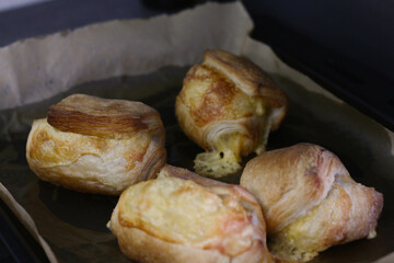 Homemade pastry puff buns with cheese on a baking sheet close-up