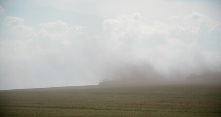 Tractors Blowing Dust On Field