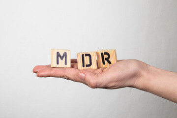 MDR Medical Device Regulation. Wooden letters in a woman's hand