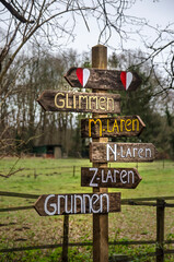 Zuidlaren,The Netherlands, December 8, 2019: handmade wooden sign indicating place names along the...