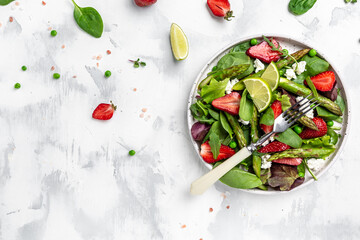 Healthy salad. green asparagus, strawberry, rocket and cottage cheese. Healthy balanced eating. banner, menu, recipe place for text, top view
