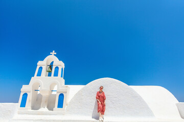 Beautiful girl in Oia village on Santorini island