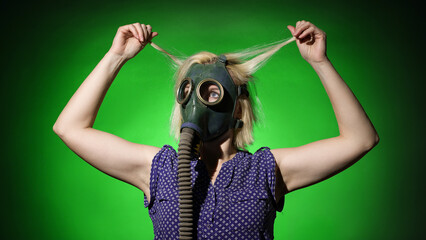 a woman in a gas mask tears her hair out of horror on a dark background
