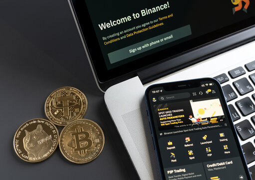 Amsterdam, Netherlands - April 18, 2022: Binance mobile app on iPhone screen and MacBook display. Binance - largest cryptocurrency exchange market.