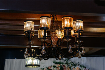 Beautiful classic chandelier hanging from the ceiling in retro style.