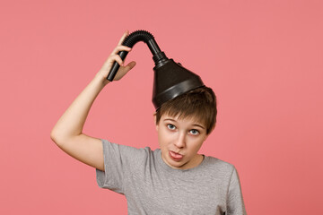 funny boy in a gray t-shirt put on a big funnel on his head, pink background