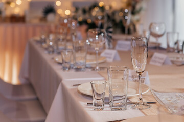 Serving a festive wedding table. Glass goblets close-up.