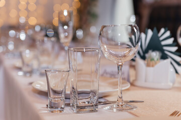 Serving a festive wedding table. Glass goblets close-up.