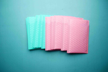  pink and green color paper bubble envelope on table 