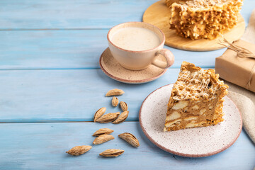 Traditional lithuanian cake shakotis with cup of coffee on blue, side view, copy space.