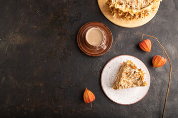 Traditional lithuanian cake shakotis with cup of coffee on black, top view, copy space.