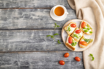 White bread sandwiches with cream cheese, tomatoes and microgreen on gray. top view.