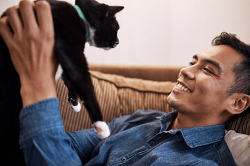 You are such a beautiful boy. Shot of a young man playing with his cat.