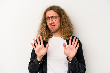 Young caucasian man isolated on white background rejecting someone showing a gesture of disgust.