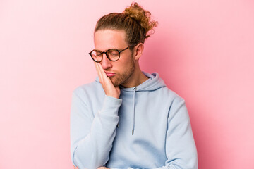 Young caucasian man isolated on pink background who is bored, fatigued and need a relax day.