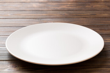 Perspective view of empty light plate on wooden background. Empty space for your design