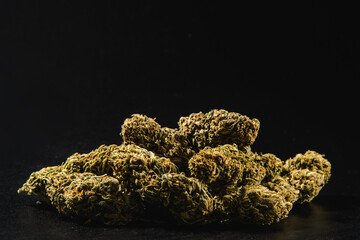 Pile of marijuana buds on a black background.