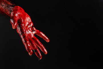 Obraz na płótnie Canvas Close-up of a male hand stained with blood on a black background. 