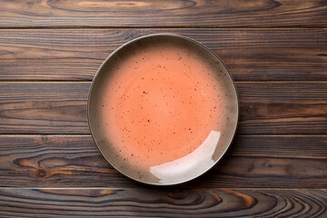 Top view of empty red plate on wooden background. Empty space for your design