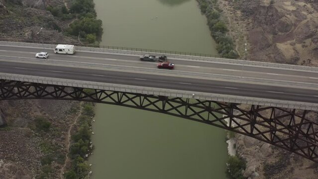 Birds Eye Aerial View of Highway Traffic on Perrine Truss Arch Span Bridge Above Deep Canyon of Snake River, Idaho USA Next to Shoshone Falls Park - Drone Tracking Back to Reveal Wate