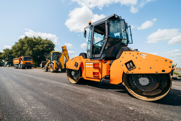 Vibratory asphalt roller compactor compacting new asphalt pavement. Road service repairs the highway