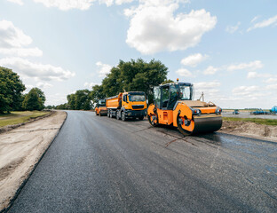 Vibratory asphalt rollers compactor and truckstanding on the side of the road. Road service build a new highway